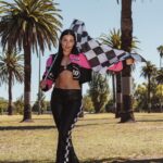 Woman in racing-inspired outfit holding checkered flag at Kittens Grand Prix Kittens Club